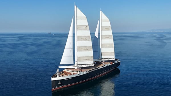 Aerial photograph of new modern cargo ship with two sets of vertical sails, in bright sunshine and blue water